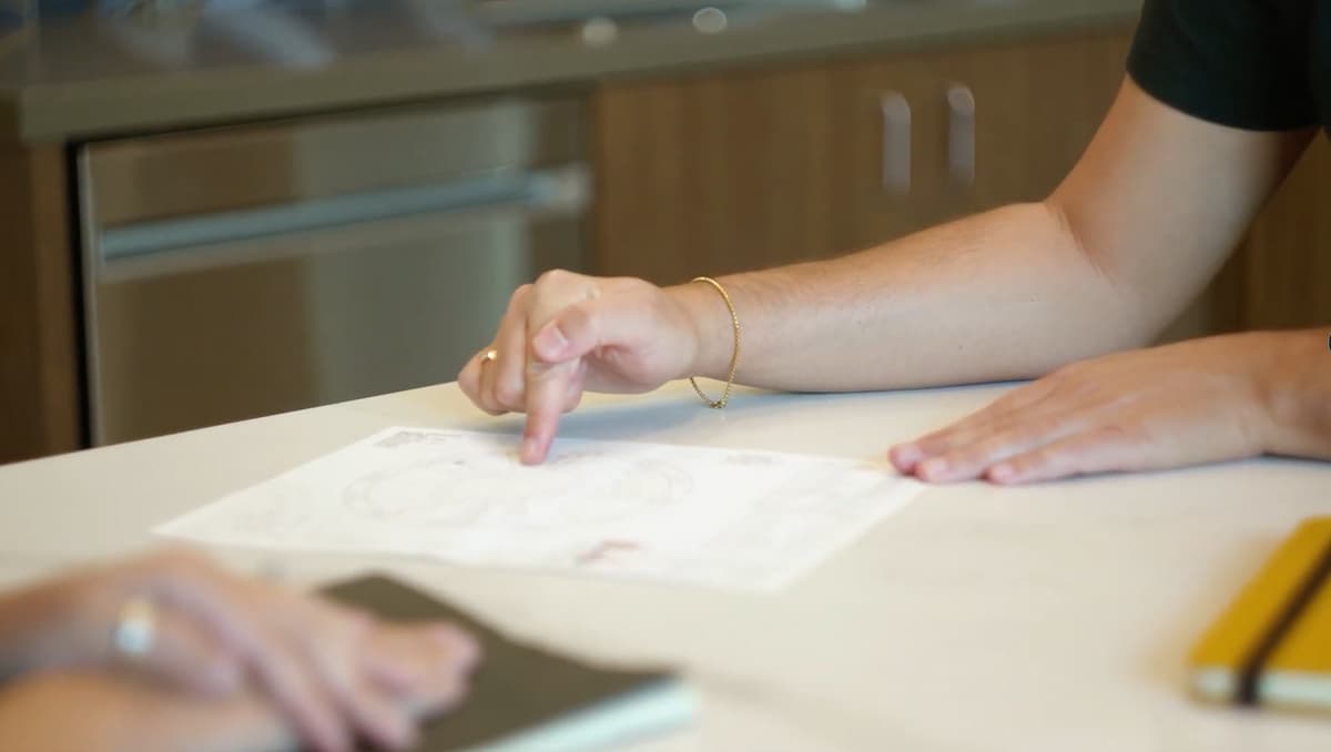 Pointing to details on a printed birth chart during a reading session